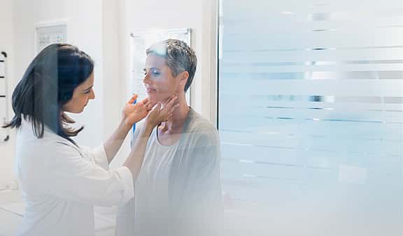 Young, female doctor confidently cares for patient with medical equipment leased with grenke in bright open medical practice