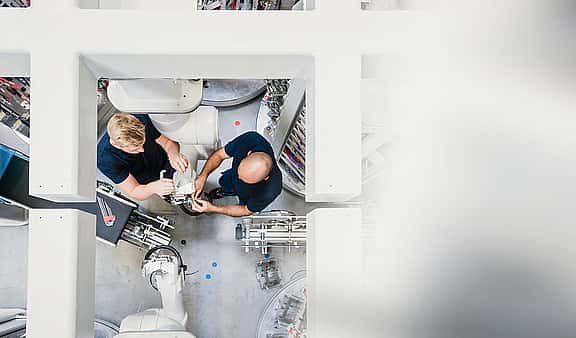 Engineers work with their manufacturing equipment with leasing with grenke