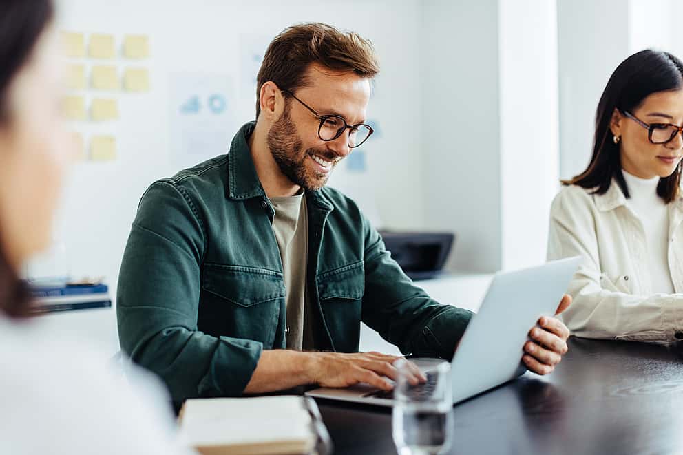 Group of five business people in a meeting room, symbolising grenke's long-term partnerships and strategic business support for reseller partners with speed, flexibility, and expert knowledge.